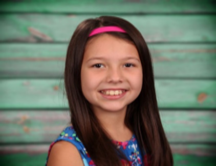 A child smiling for the cameraDescription automatically generated with low confidence
